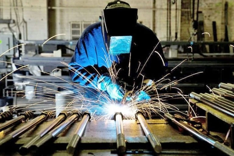 man welding steel together