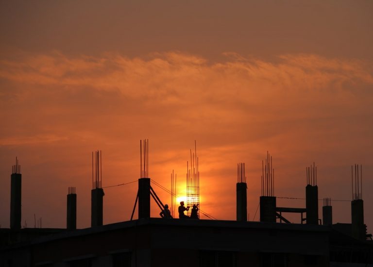 photo of an unfinished construction project with a sunset over