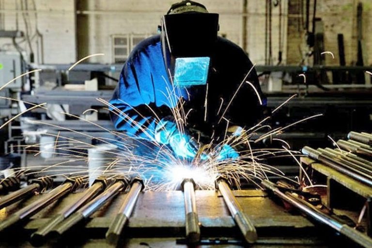 man welding steel together