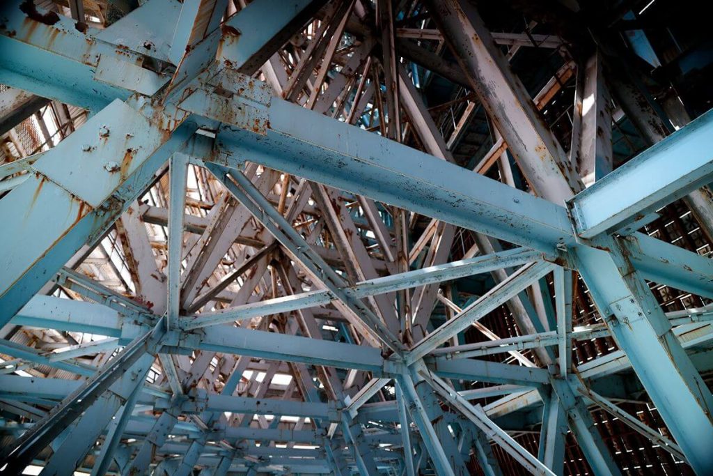 Steel beams and structural connections showing visible rust and corrosion after prolonged moisture exposure