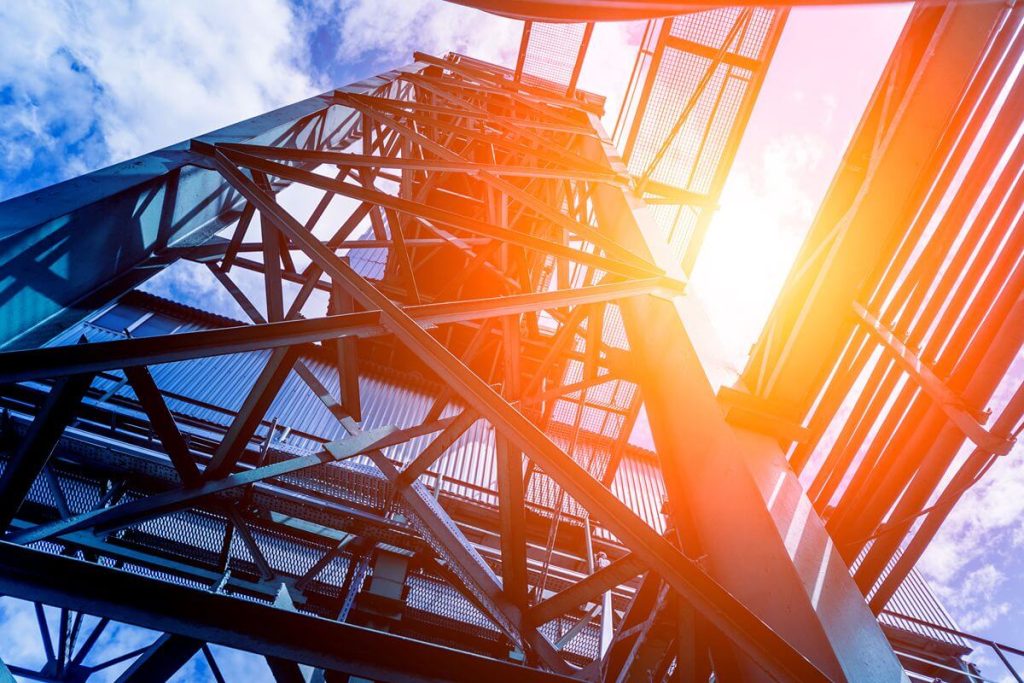 Low-angle view of a durable steel structural framework against a bright sky